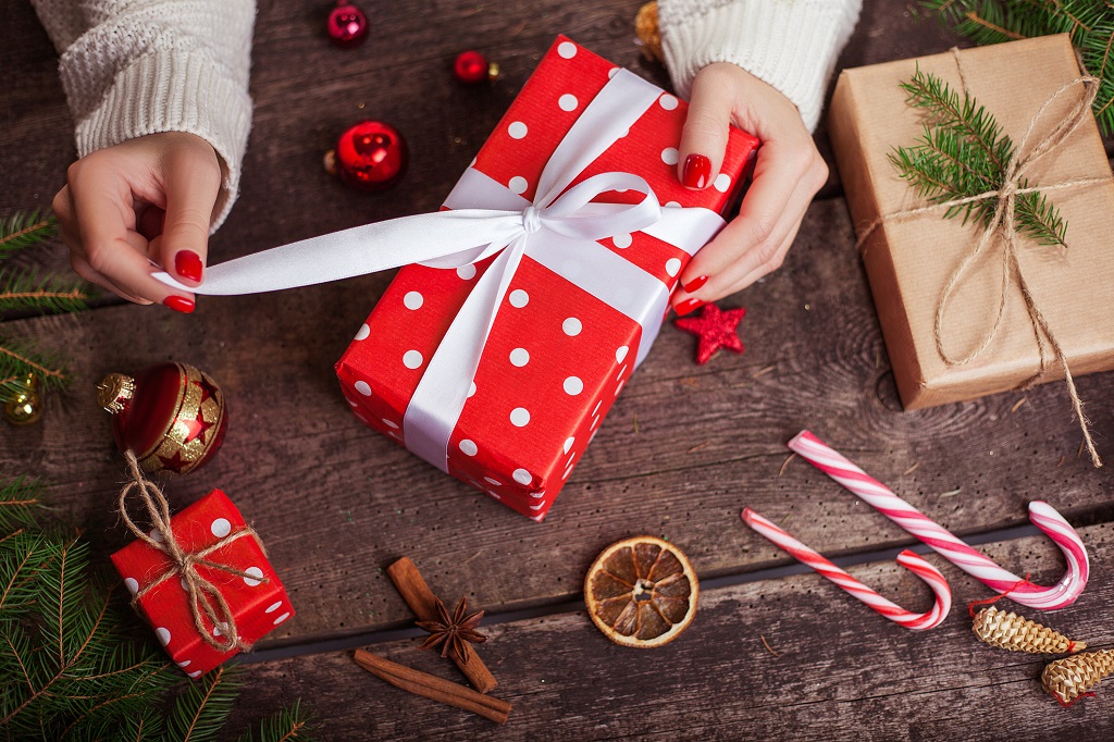 Gift box in wrapping paper with satin ribbon. Merry Christmas holiday concept.